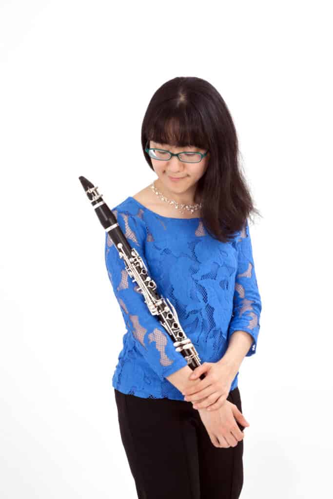 Picture of Anna Hashimoto cradling her clarinet