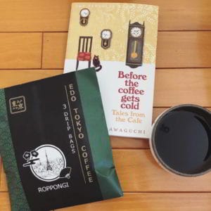 Photograph of a bag of coffee, a book on coffee, and a black coffee